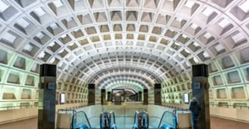 Washington Metro station with vaulted concrete ceiling, escalators, and geometric architectural design.