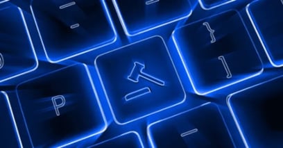 Close-up of a keyboard with a glowing gavel symbol on one key.