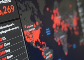 A digital dashboard displays a world map with red dots indicating outbreak locations and a list of countries with confirmed case numbers.