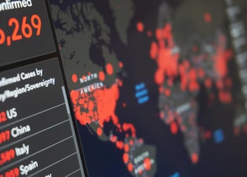 A digital dashboard displays a world map with red dots indicating outbreak locations and a list of countries with confirmed case numbers.