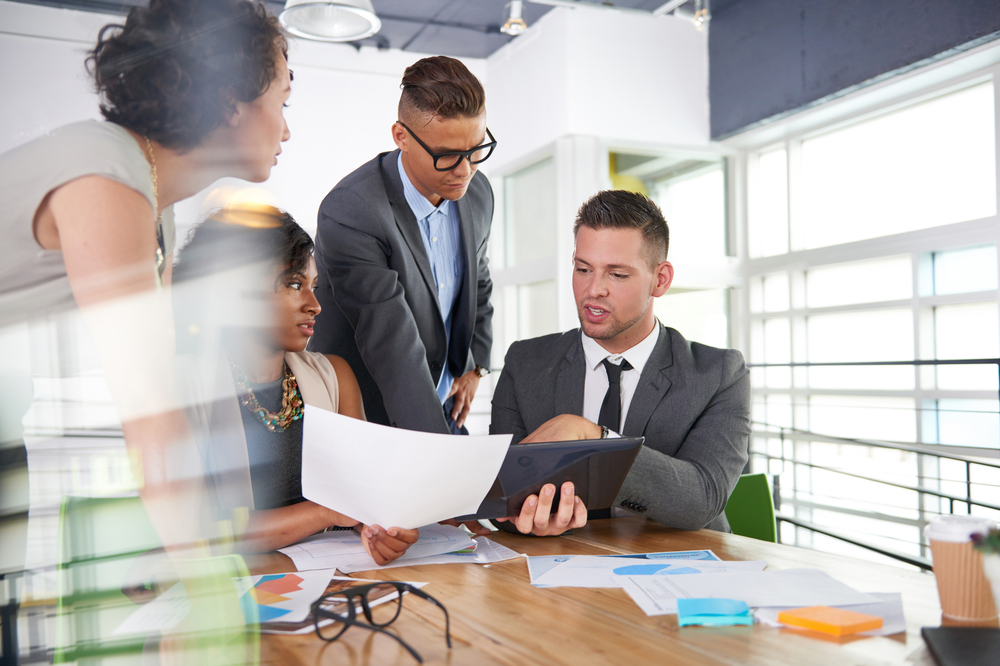 team of successful business people having a meeting in executive sunlit office